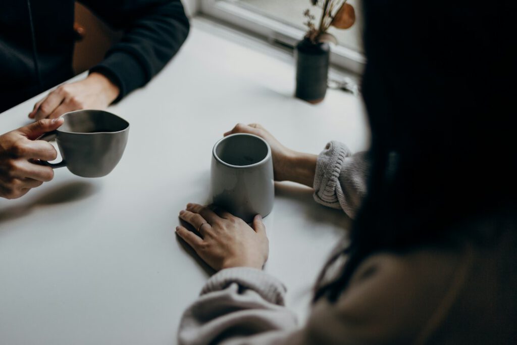 Zwei Menschen im ruhigen Gespräch bei einer Tasse